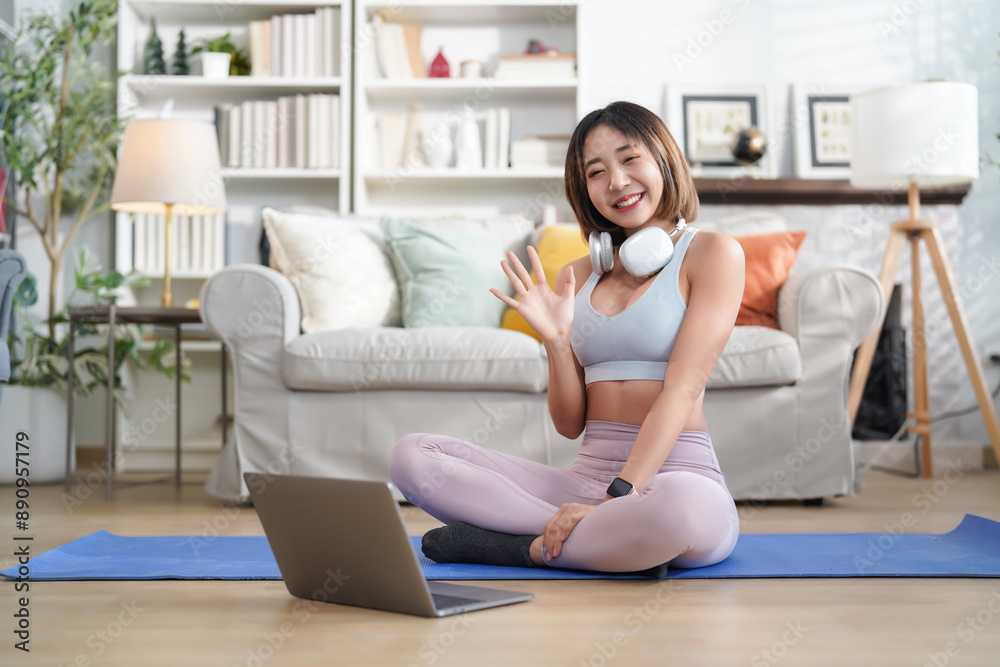 portrait young attractive asian girl in sportswear with headset and laptop prepare for exercise indoors in the living room portrait young attractive asian girl in sportswear with headset and laptop prepare for exercise indoors in the living room