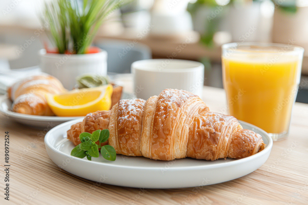 A glass of orange juice and croissant on table at hotel restaurant cafe