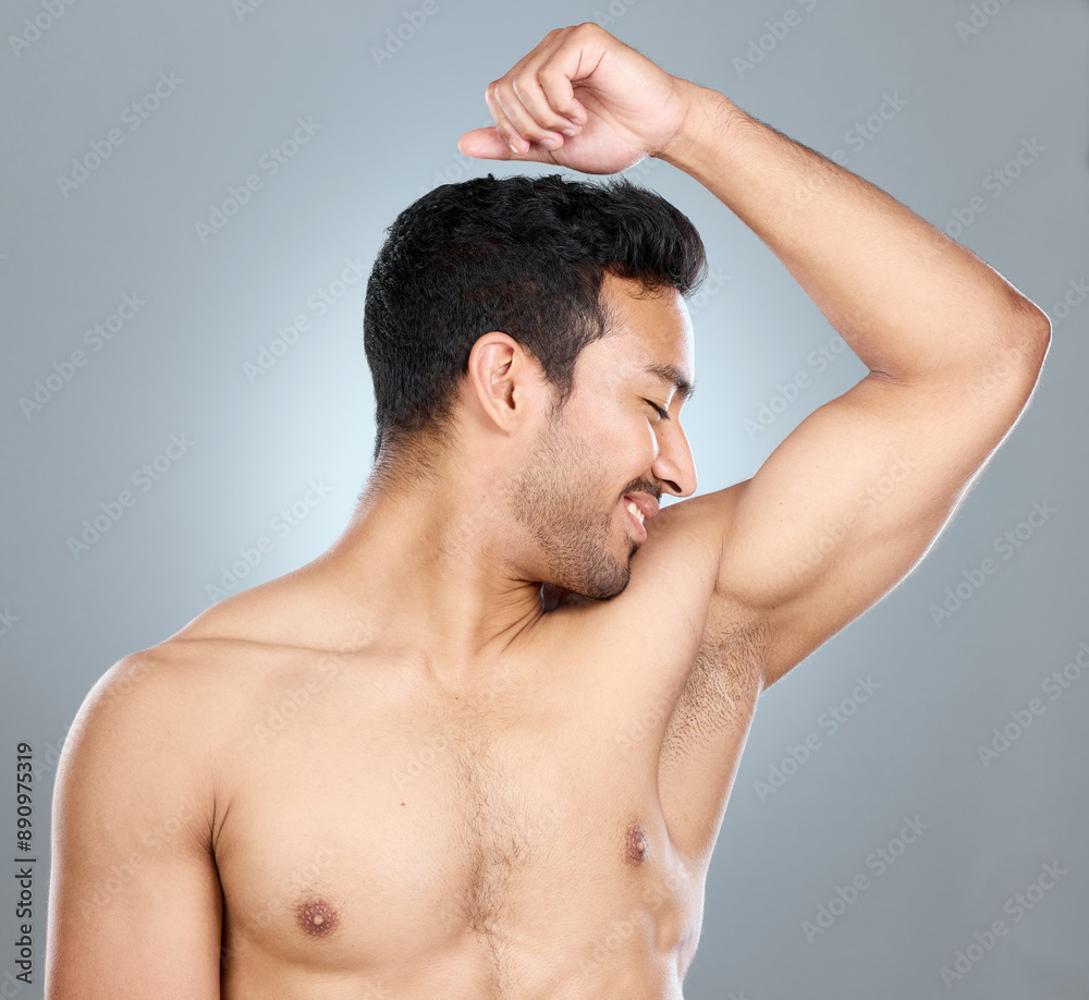 Health, fresh and man smelling armpit in studio for hygiene, clean and wellness routine. Wellness, fragrance and male person checking underarm scent for deodorant or perfume by gray background. Health, fresh and man smelling armpit in studio for hygiene, clean and wellness routine. Wellness, fragrance and male person checking underarm scent for deodorant or perfume by gray background.