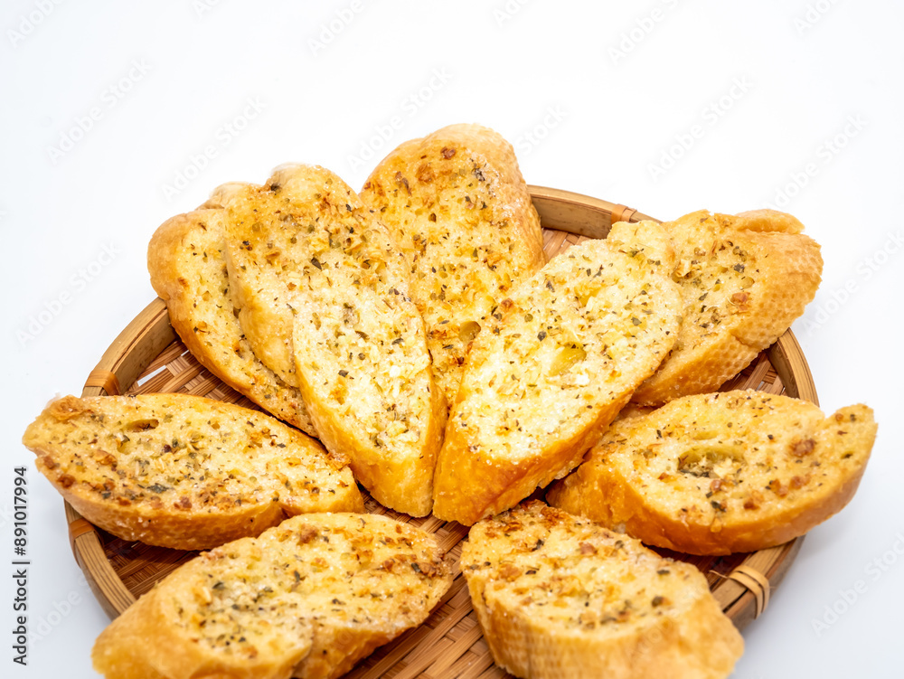 Composition with slices of toasted garlic bread on woven basket and on white background. Composition with slices of toasted garlic bread on woven basket and on white background.