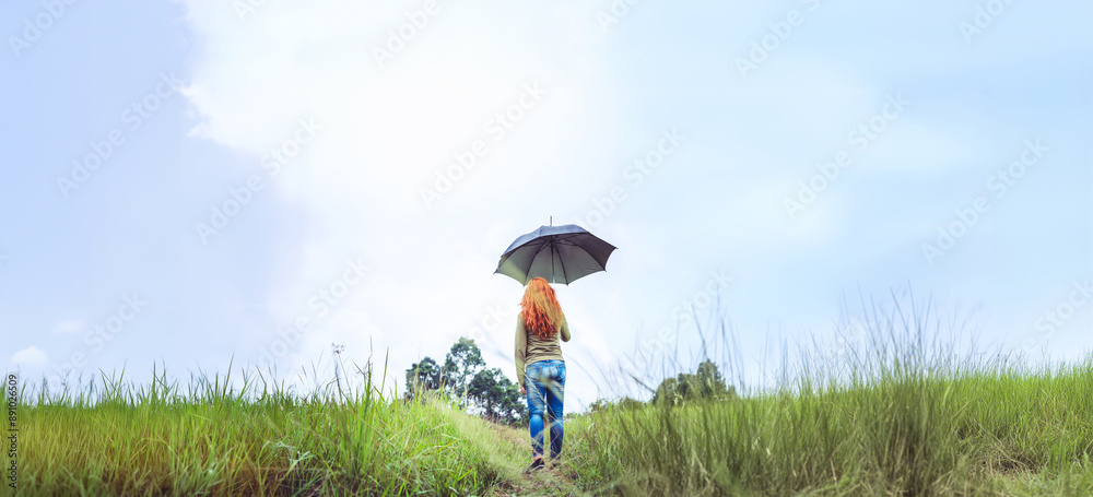 Women standing umbrella On the green meadow in the rainy season. Asian women Women standing umbrella On the green meadow in the rainy season. Asian women