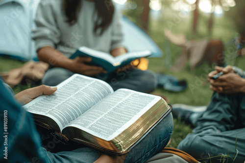 Young Group Reading and Discussing Bible Outdoors, Christian Fellowship and Prayer Meeting at Park