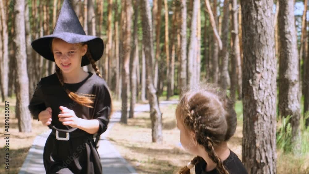 Children girls in carnival costumes of witches outdoor are enjoying Halloween holiday. witch's hat and jack o lantern.
