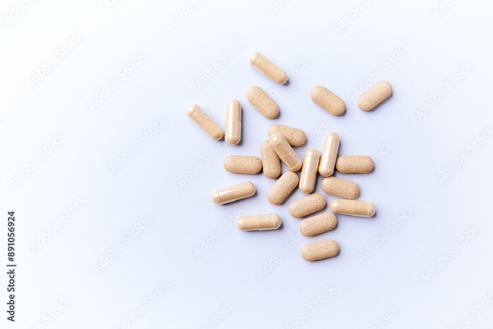 Ashwagandha (Withania somnifera) tablets and capsules on paper background. Soft focus.. Close up. Copy space. Ashwagandha (Withania somnifera) tablets and capsules on paper background. Soft focus.. Close up. Copy space.