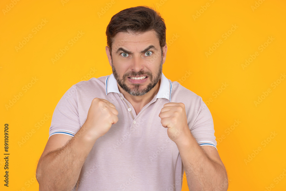 Angry man screaming. Portrait of young angry man isolated on yellow background. Angry male face. Guy with nervous crisis. Negative human emotions facial expression feelings attitude. Angry man screaming. Portrait of young angry man isolated on yellow background. Angry male face. Guy with nervous crisis. Negative human emotions facial expression feelings attitude.