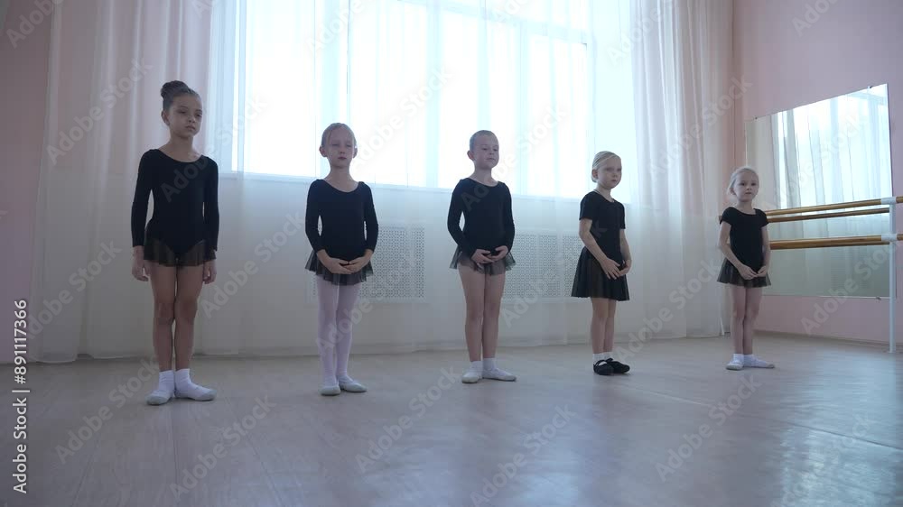 Cute little girls in black swimsuits and tutu practice ballet in class. Cute little girls in black swimsuits and tutu practice ballet in class.