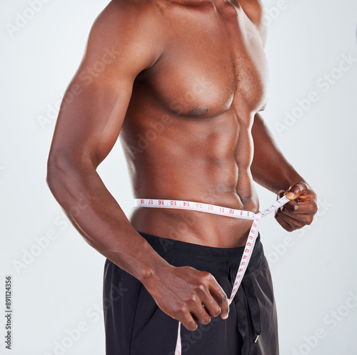 Foto Man, size and waist with measuring tape for weightloss, diet or slimline on a gray studio background