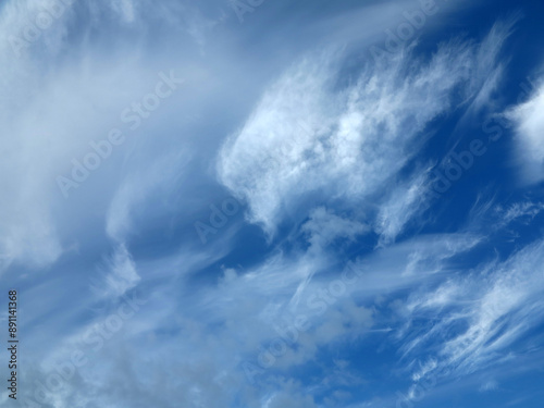 Blue sky and sparce white clouds photo