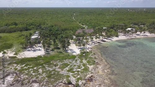 drone shoot in the caribbean beach with pamsl trees and wood house 2