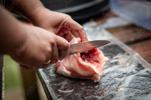 Someone is cutting chicken to cook