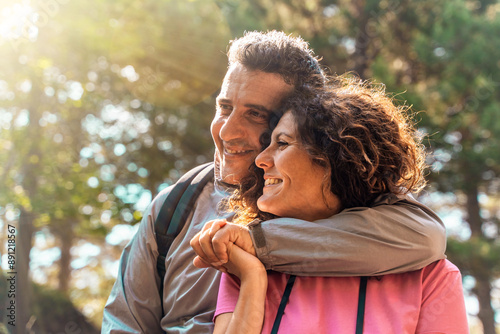 Authentic middle aged couple embracing and smiling in nature, romantic relationship lifestyle portrait photo