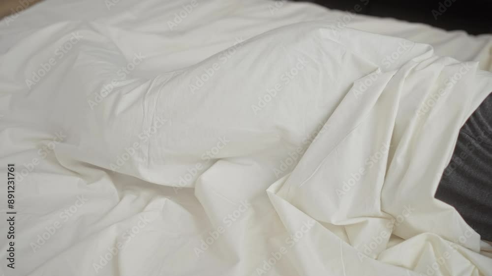 Young man sleeping peacefully in bed with white sheets in a cozy bedroom environment Young man sleeping peacefully in bed with white sheets in a cozy bedroom environment