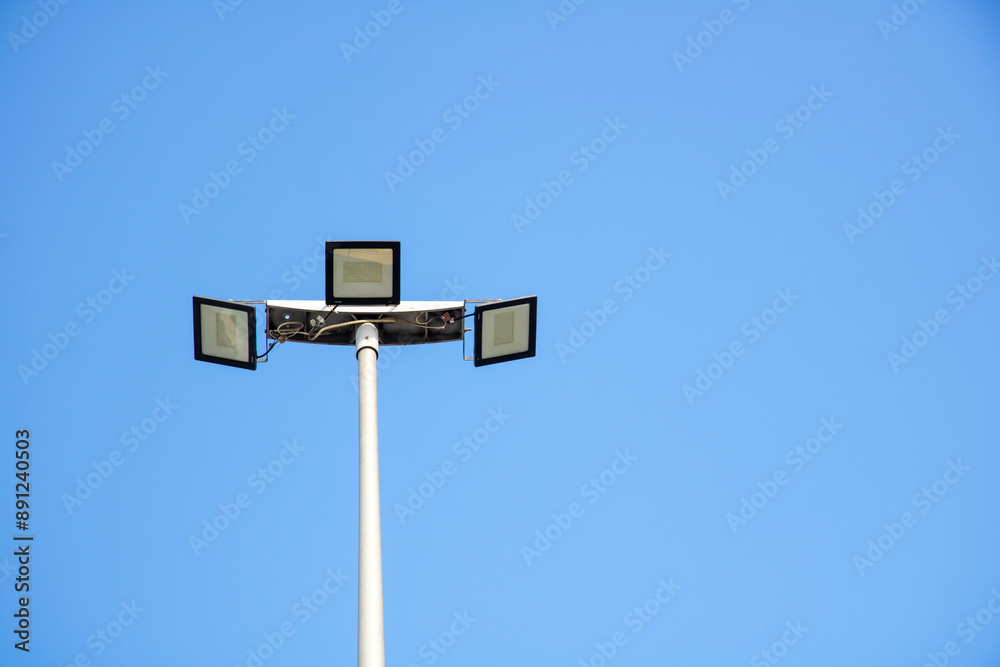 A street light stands tall against the backdrop of a clear blue sky A street light stands tall against the backdrop of a clear blue sky
