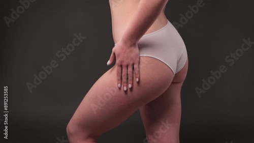 Girl pulls the skin on the abdomen and on the hips showing the body fat. Treatment and disposal of excess weight, the deposition of subcutaneous fat.