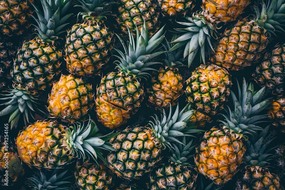 Close-up view of a vibrant pineapple with water droplets, illuminated by warm light, creating a summery atmosphere. Close-up view of a vibrant pineapple with water droplets, illuminated by warm light, creating a summery atmosphere.