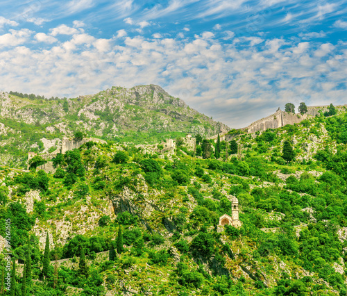 beautiful highland landscape of majectic green mountain with anciant buildings on top and slopes and scenic blue cloudy sky on background photo