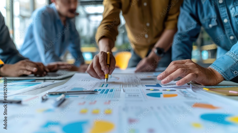 A close-up of hands analyzing financial charts and graphs during a team meeting in a bright, modern workspace. A close-up of hands analyzing financial charts and graphs during a team meeting in a bright, modern workspace.