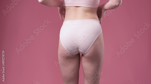 Girl pulls the skin on the abdomen and on the hips showing the body fat. Treatment and disposal of excess weight, the deposition of subcutaneous fat.