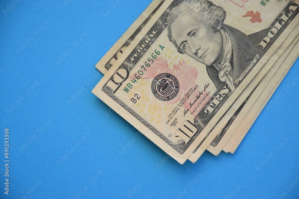 Bundle of ten dollar bills banknotes on blue background Bundle of ten dollar bills banknotes on blue background