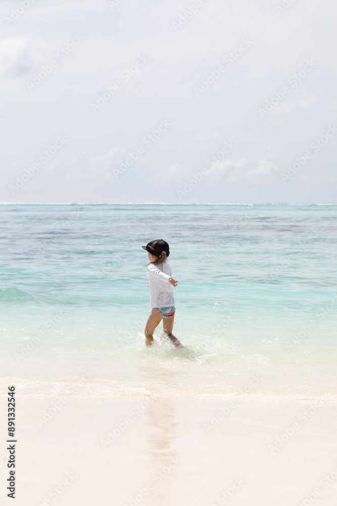 Young girl running joyfully on the beach, white sand, vitamin d, holidays with children, summer holidays