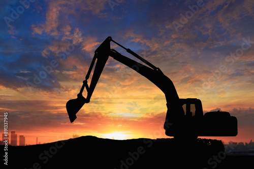 Crawler excavators silhouette are digging the soil in the construction site. on sunset background