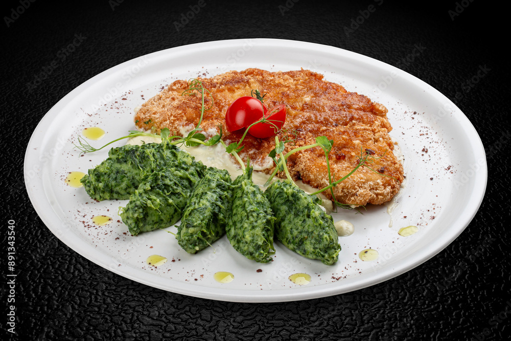 Chicken schnitzel served with sauce, accompanied by broccoli and cheese fritters. Chicken schnitzel served with sauce, accompanied by broccoli and cheese fritters.