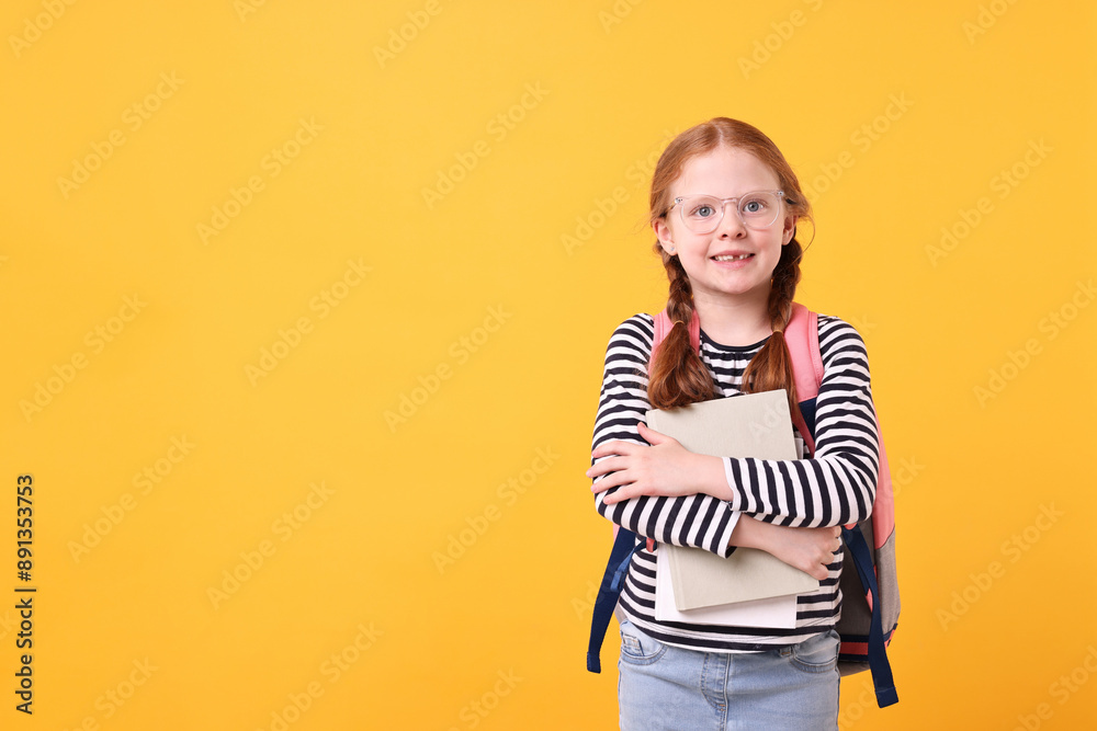 Naklejka premium Smiling girl with book on yellow background. Space for text