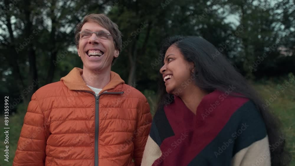 Two friends or a couple talking and laughing together outside in a park. Lifestyle slow motion footage Two friends or a couple talking and laughing together outside in a park. Lifestyle slow motion footage