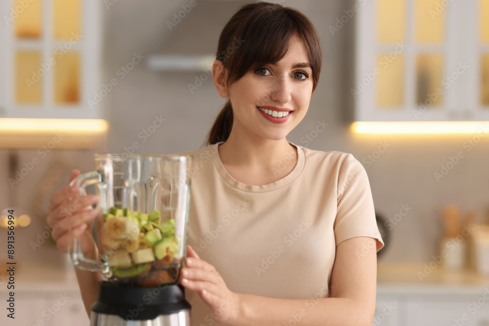 Young woman making delicious smoothie with blender in kitchen Young woman making delicious smoothie with blender in kitchen