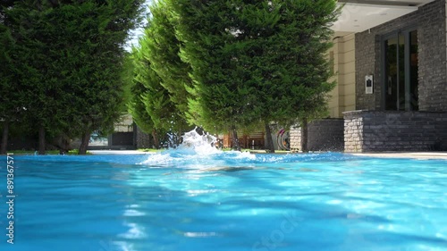 Young woman jumping in the pool.