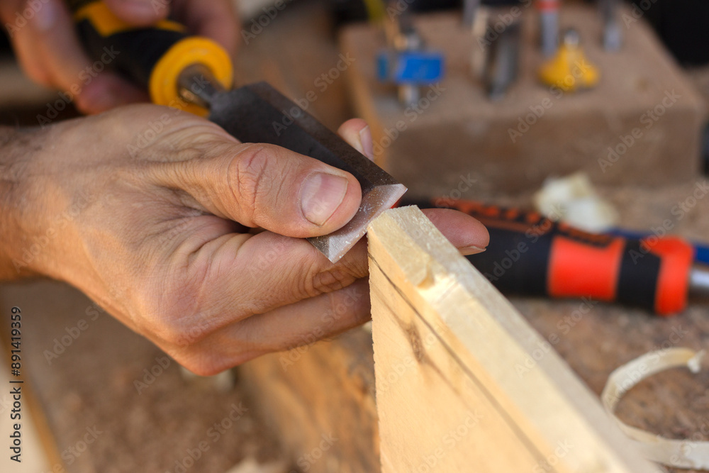carpenter cutting wood with a chisel 