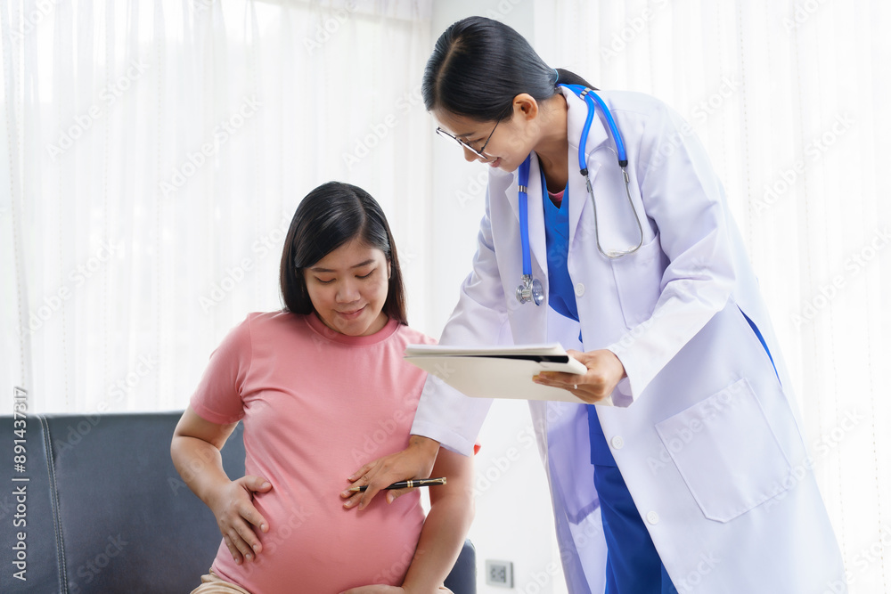 Obraz premium A pregnant woman sits on the sofa in the clinic. The doctor examines her abdomen and reviews the ultrasound results. Offering encouragement, the doctor holds her hand, providing support and care.