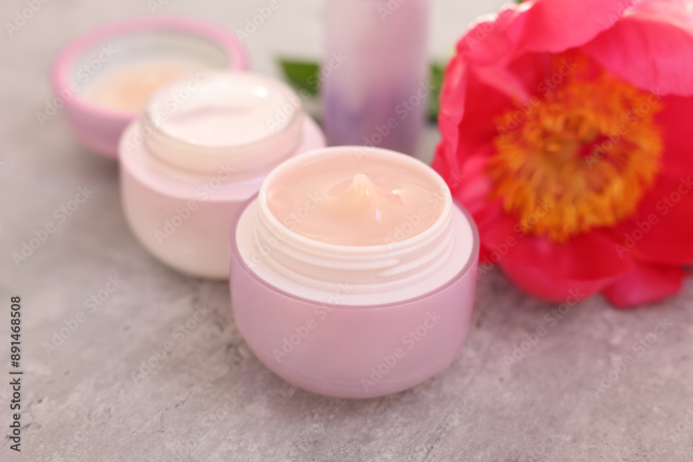 Set of different cosmetic products and peony flower on gray table, closeup Set of different cosmetic products and peony flower on gray table, closeup