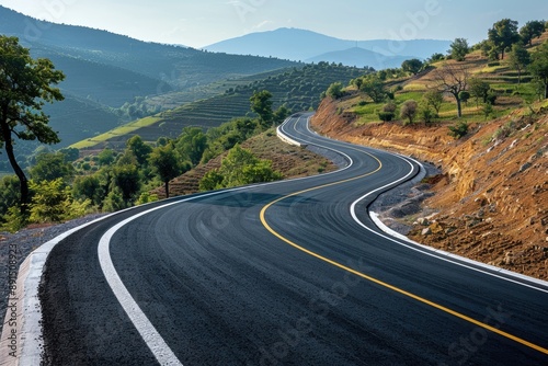 Winding Road Through Scenic Countryside with Rolling Hills and Clear Blue Sky