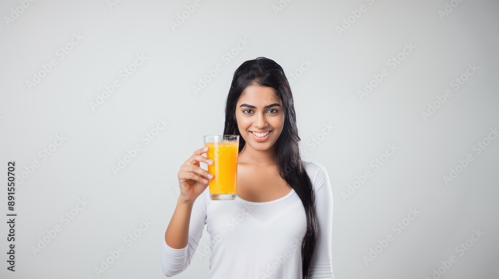 An Indian woman holding a glass of orange juice isolated on a white background, showing enjoyment and happiness, refreshing drink An Indian woman holding a glass of orange juice isolated on a white background, showing enjoyment and happiness, refreshing drink