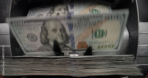 Money counting machine quickly, reliably, accurately counts large sums of American dollars. Banknote counter counts dollars. Cash is stacked in neat piles. Profit and financial investment, copy space.