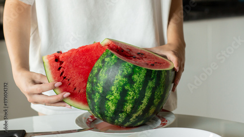 Woman slice fresh watermelon at kitchen, closeup