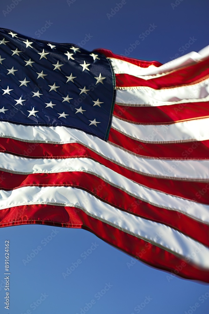 Obraz premium A detailed close-up of a worn American flag, with stars and stripes, illuminated by natural sunlight indoors..