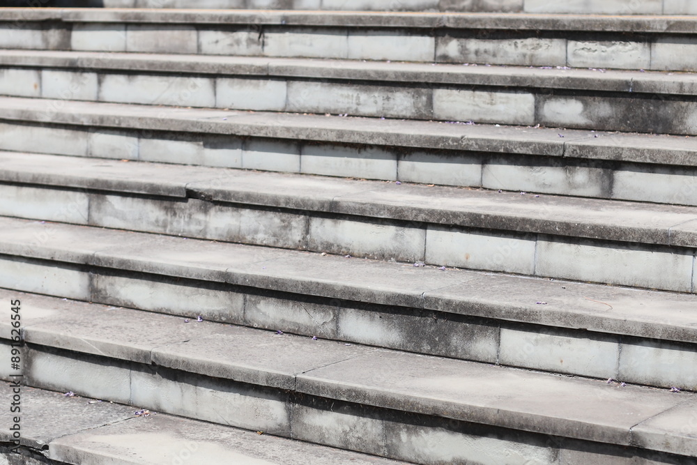 A person sitting on a set of stairs with steps and railing. A person sitting on a set of stairs with steps and railing.