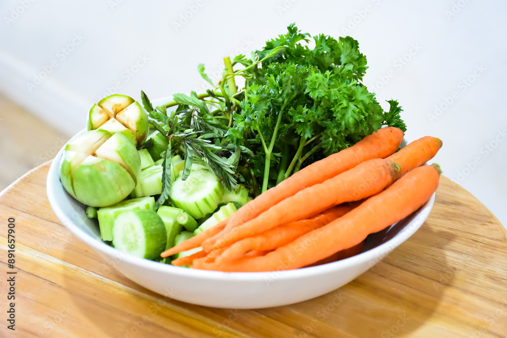 Healthy food: Fresh vegetables rosemary, carrots, brinjal and cucumber in a white ceramic plate. Healthy food: Fresh vegetables rosemary, carrots, brinjal and cucumber in a white ceramic plate.