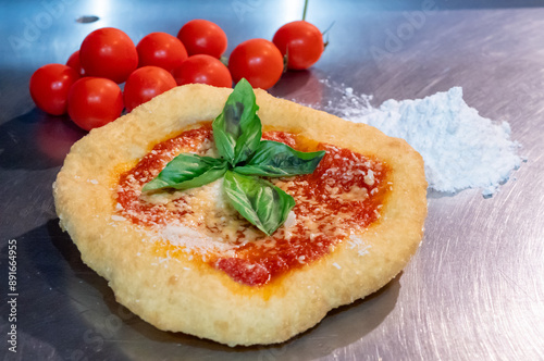 Neapolitan fried pizza with tomato sauce cheese and basil leaves, called Montanara