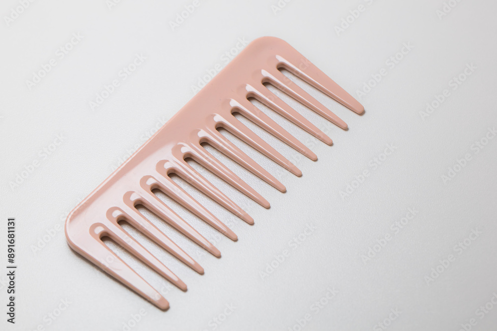 Closeup of pink wide-teeth comb isolated on white background Closeup of pink wide-teeth comb isolated on white background