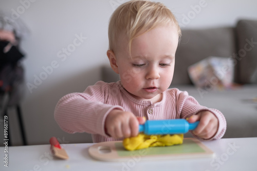  smiling little toddler working with plasticine in art and craft 