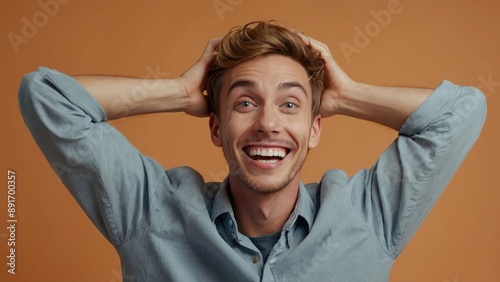 Man With Brown Hair and Blue Shirt Holding His Head in Excitement