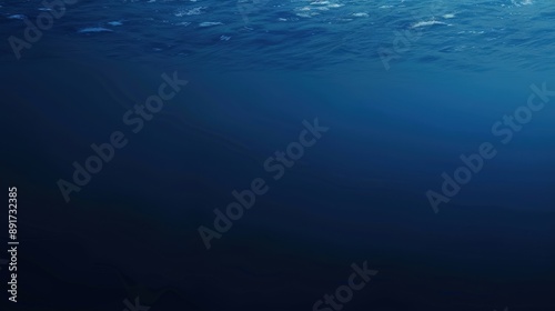 An underwater view of the ocean with the sunlight filtering through the surface of the water, creating a gradient effect