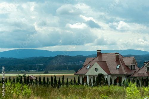 Fototapeta Naklejka Na Ścianę i Meble -  Beautiful one-story house in a field with a backdrop of mountains and beautiful nature. Concept of country life, privacy, silence and solitude. High quality photo