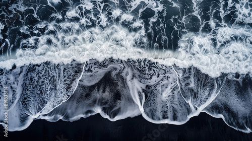 top view of ocean waves with white foam and black sand, aerial view 