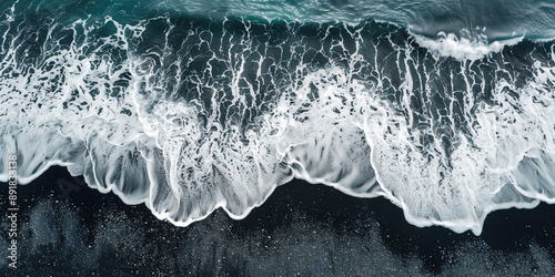 top view of ocean waves with white foam and black sand, aerial view 