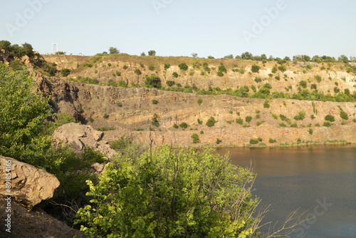 Rocky quarry lake shore in summer photo