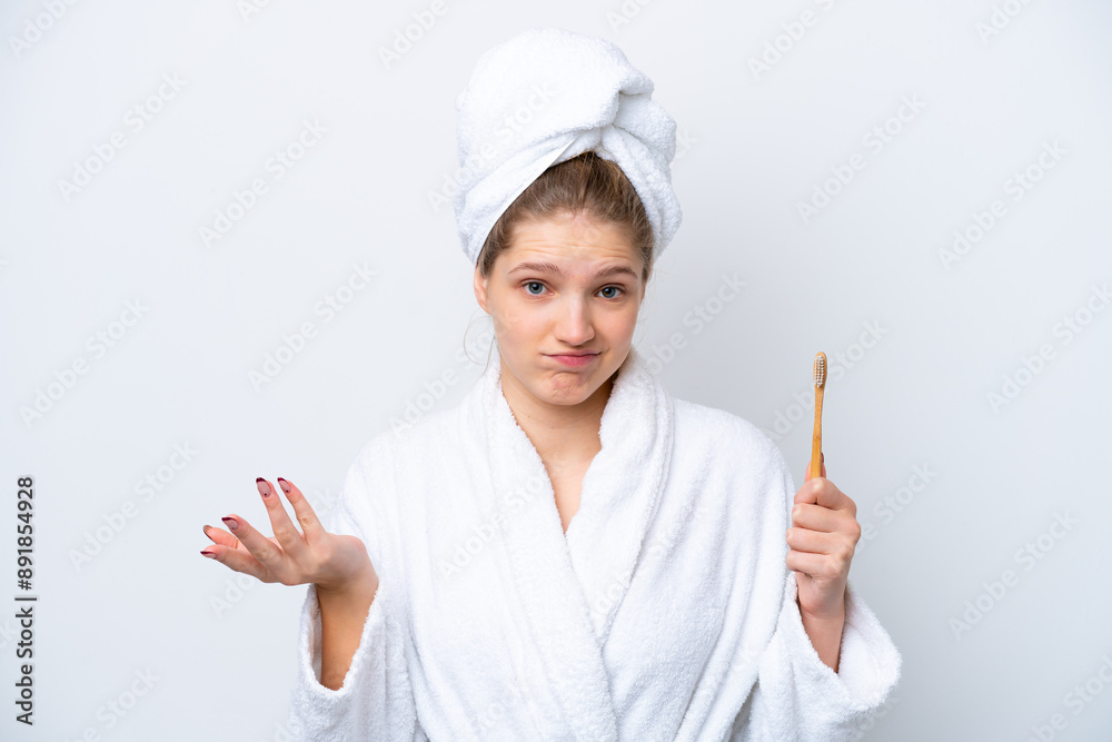 Teenager Russian girl brushing teeth isolated on white background making doubts gesture while lifting the shoulders Teenager Russian girl brushing teeth isolated on white background making doubts gesture while lifting the shoulders